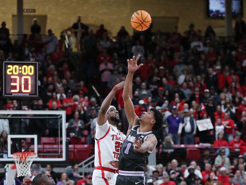 Jan 13, 2024; Lubbock, Texas, USA;  Texas Tech Red Raiders forward Warren Washington (22) and Kansas State Wildcats wing David N Guessan (1) vie for the opening tip at United Supermarkets Arena. Mandatory Credit: Michael C. Johnson-USA TODAY Sports