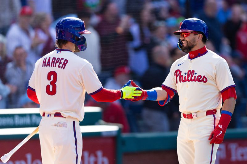 Apr 13, 2024; Philadelphia, Pennsylvania, USA; Philadelphia Phillies designated hitter Kyle Schwarber (12) celebrates with first base Bryce Harper (3) after hitting a home run during the first inning against the Pittsburgh Pirates at Citizens Bank Park. Mandatory Credit: Bill Streicher-USA TODAY Sports