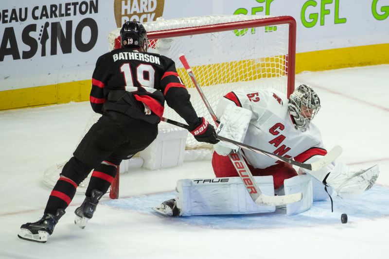 Dec 12, 2023; Ottawa, Ontario, CAN; Carolina Hurricanes goalie Pyotr  Kochetkov (52) makes a save on a shot from  Ottawa Senators right wing Drake Batherson (19) in the third period at the Canadian Tire Centre. Mandatory Credit: Marc DesRosiers-USA TODAY Sports.