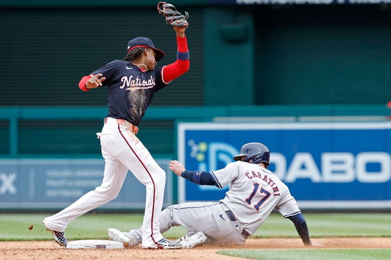 Apr 21, 2024; Washington, District of Columbia, USA; Houston Astros catcher Victor Caratini (17) slides into second base ahead of a tag by Washington Nationals shortstop CJ Abrams (5) after a wild pitch by Nationals pitcher Mitchell Parker (not pictured) during the sixth inning at Nationals Park. Mandatory Credit: Geoff Burke-USA TODAY Sports