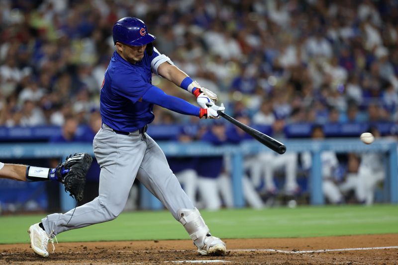 Sep 10, 2024; Los Angeles, California, USA;  Chicago Cubs designated hitter Seiya Suzuki (27) hits a RBI single during the eighth inning against the Los Angeles Dodgers at Dodger Stadium. Mandatory Credit: Kiyoshi Mio-Imagn Images