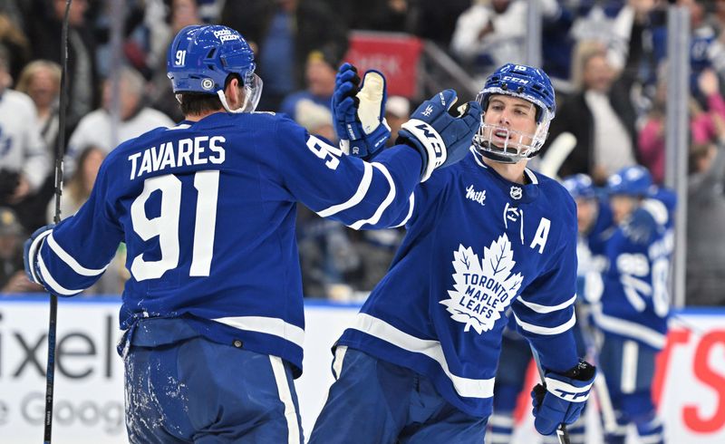 Dec 2, 2023; Toronto, Ontario, CAN; Toronto Maple Leafs forward Mitchell Marner (16) slaps hands with forward John Tavares (91) after a goal against the Boston Bruins in the third period at Scotiabank Arena. Mandatory Credit: Dan Hamilton-USA TODAY Sports