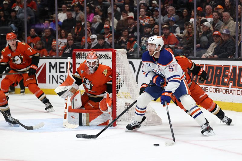 Feb 25, 2026; Anaheim, California, USA;  Edmonton Oilers center Connor McDavid (97) controls the puck as Anaheim Ducks goaltender Lukas Dostal (1) defends the goal during the first period at Honda Center. Mandatory Credit: Kiyoshi Mio-Imagn Images