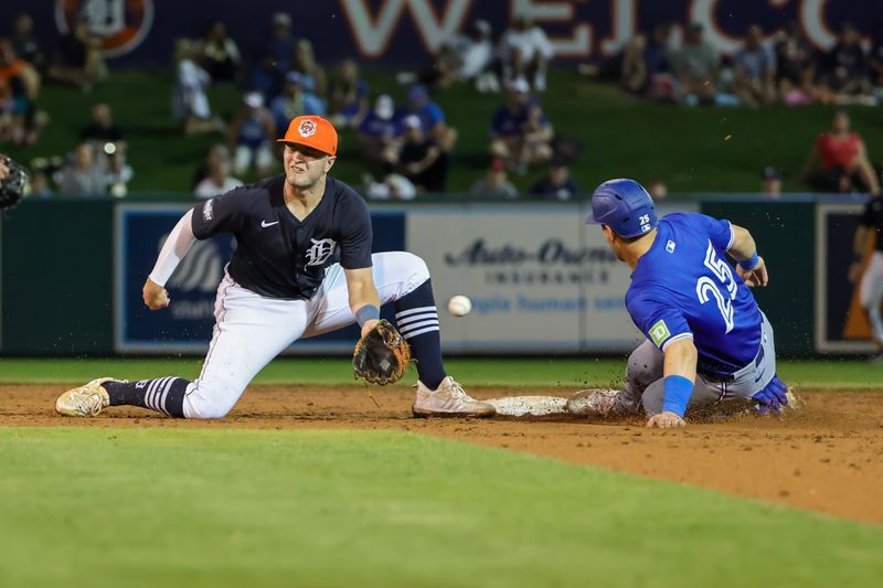 Mar 7, 2024; Lakeland, Florida, USA; Toronto Blue Jays left fielder Daulton Varsho (25) slides safely into second during the fourth inning against the Detroit Tigers at Publix Field at Joker Marchant Stadium. Mandatory Credit: Mike Watters-USA TODAY Sports