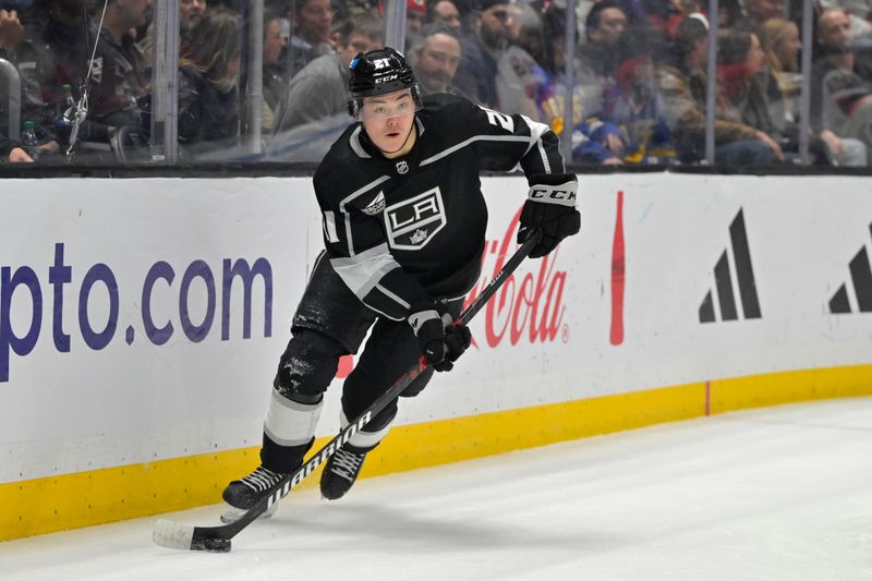 Mar 3, 2024; Los Angeles, California, USA;  Los Angeles Kings defenseman Jordan Spence (21) handles the puck in the first period against the New Jersey Devils at Crypto.com Arena. Mandatory Credit: Jayne Kamin-Oncea-USA TODAY Sports