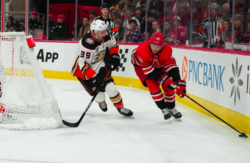 Jan 11, 2024; Raleigh, North Carolina, USA; Carolina Hurricanes center Jack Drury (18) skates with the puck against Anaheim Ducks center Sam Carrick (39) during the third period at PNC Arena. Mandatory Credit: James Guillory-USA TODAY Sports