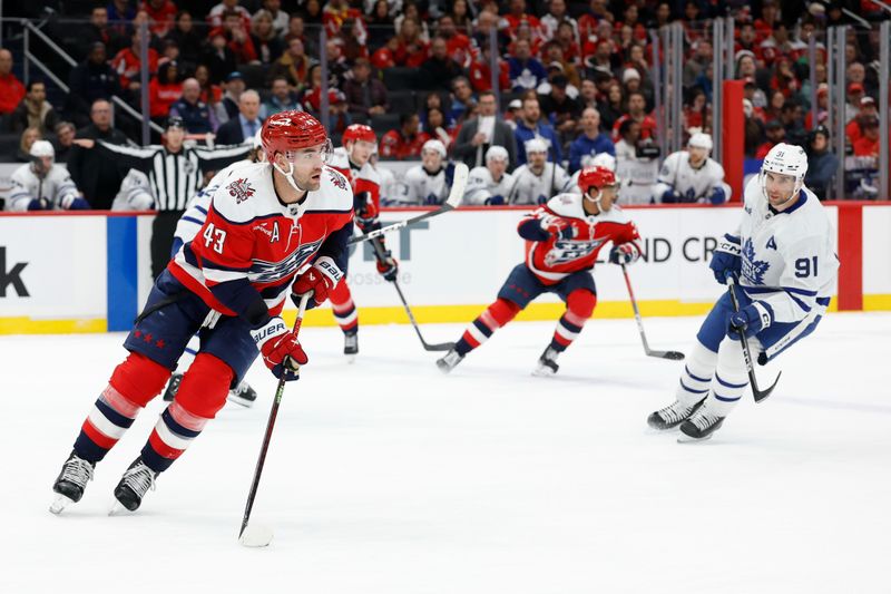 Nov 28, 2025; Washington, District of Columbia, USA; Washington Capitals right wing Tom Wilson (43) skates with the puck as Toronto Maple Leafs center John Tavares (91) chases during the second period at Capital One Arena. Mandatory Credit: Geoff Burke-Imagn Images