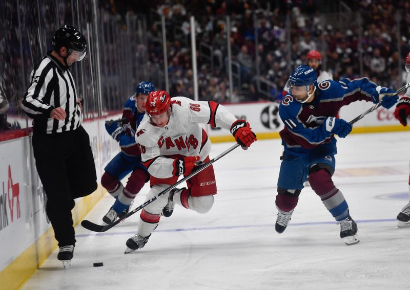 Oct 21, 2023; Denver, Colorado, USA; Carolina Hurricanes Callahan Burke (68) chases down the puck as Colorado Avalanche center Andrew Cogliano (11) comes in on the play in the first period at Ball Arena. Mandatory Credit: John Leyba-USA TODAY Sports