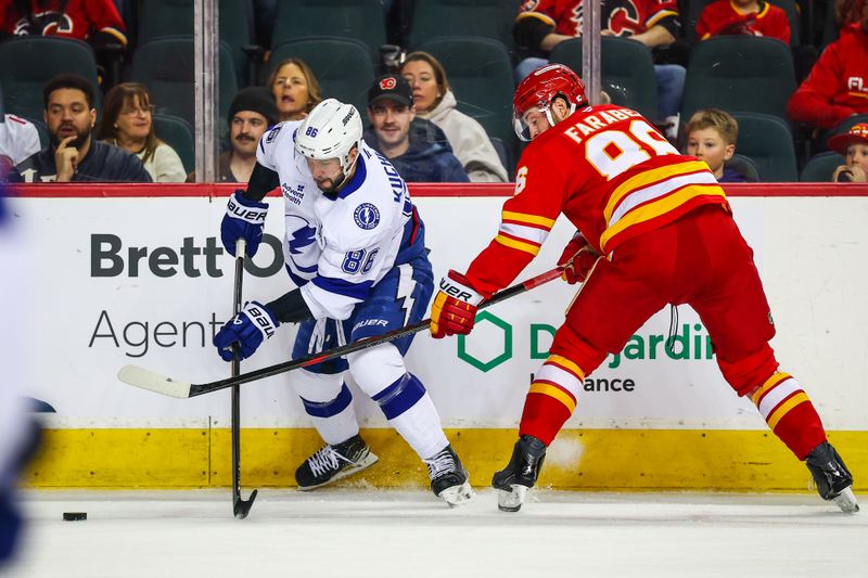 Mar 22, 2026; Calgary, Alberta, CAN; Tampa Bay Lightning right wing Nikita Kucherov (86) and Calgary Flames left wing Joel Farabee (86) battle for the puck during the first period at Scotiabank Saddledome. Mandatory Credit: Sergei Belski-Imagn Images