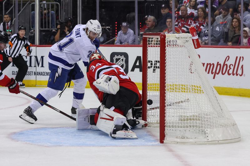 Oct 22, 2024; Newark, New Jersey, USA; Tampa Bay Lightning center Brayden Point (21) scores a goal on New Jersey Devils goaltender Jake Allen (34) during the first period at Prudential Center. Mandatory Credit: Ed Mulholland-Imagn Images