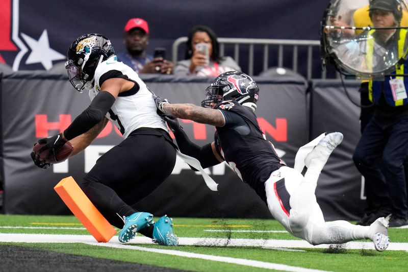 Jacksonville Jaguars wide receiver Christian Kirk catches an 8-yard touchdown pass in front of Houston Texans safety Jalen Pitre, right, during the second half of an NFL football game, Sunday, Sept. 29, 2024, in Houston. (AP Photo/Eric Christian Smith)