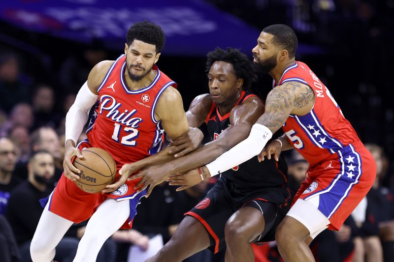 PHILADELPHIA, PENNSYLVANIA - DECEMBER 22: O.G. Anunoby #3 of the Toronto Raptors guards between Tobias Harris #12 and Marcus Morris Sr. #5 of the Philadelphia 76ers during the first quarter at the Wells Fargo Center on December 22, 2023 in Philadelphia, Pennsylvania. NOTE TO USER: User expressly acknowledges and agrees that, by downloading and or using this photograph, User is consenting to the terms and conditions of the Getty Images License Agreement. (Photo by Tim Nwachukwu/Getty Images)