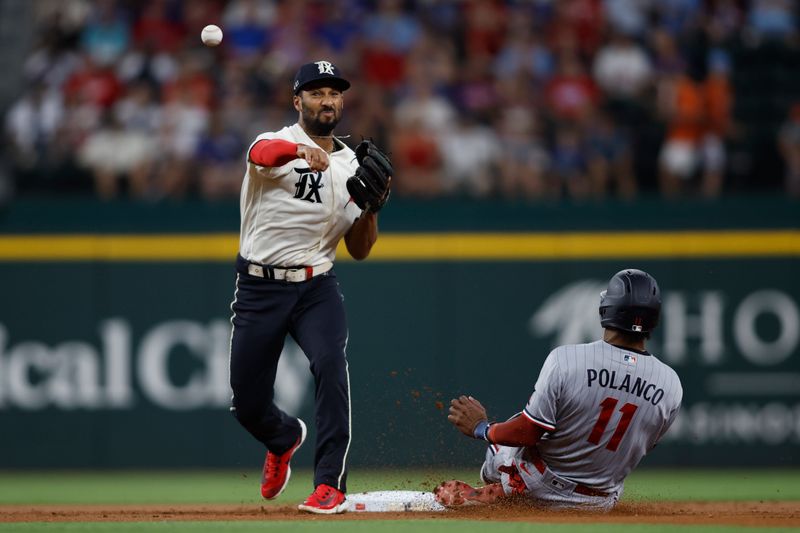 Sep 2, 2023; Arlington, Texas, USA; Texas Rangers second baseman Marcus Semien (2) turns a double play on Minnesota Twins designated hitter Jorge Polanco (11) in the first inning at Globe Life Field. Mandatory Credit: Tim Heitman-USA TODAY Sports