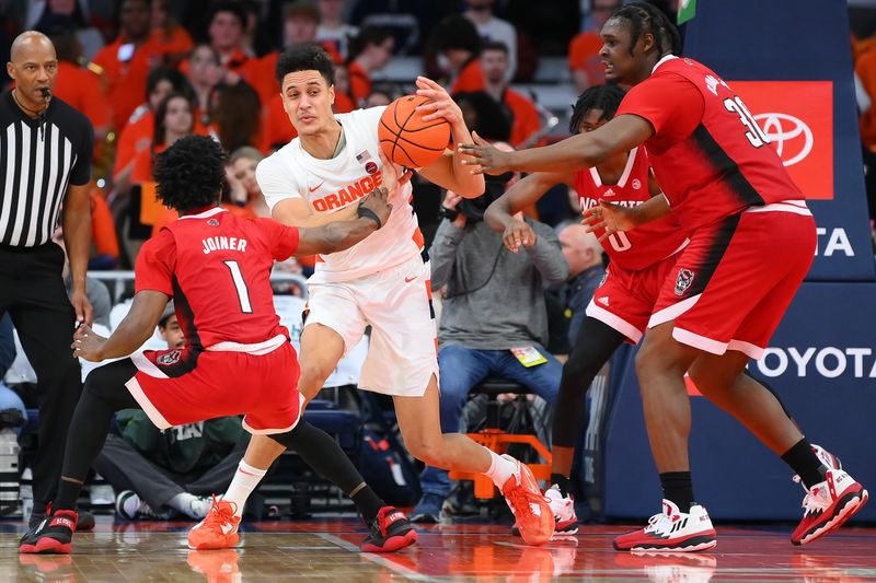 Feb 14, 2023; Syracuse, New York, USA; North Carolina State Wolfpack guard Jarkel Joiner (1) reaches for the ball controlled by Syracuse Orange center Jesse Edwards (14) during the second half at the JMA Wireless Dome. Mandatory Credit: Rich Barnes-USA TODAY Sports