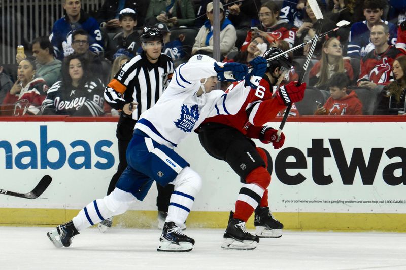 Apr 9, 2024; Newark, New Jersey, USA; Toronto Maple Leafs left wing Matthew Knies (23) and New Jersey Devils defenseman John Marino (6) compete for the puck during the first period at Prudential Center. Mandatory Credit: John Jones-USA TODAY Sports