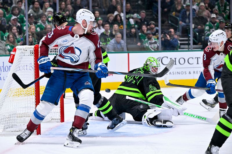 Nov 29, 2024; Dallas, Texas, USA; Dallas Stars goaltender Jake Oettinger (29) turns aside a shot by Colorado Avalanche defenseman Cale Makar (8) as right wing Valeri Nichushkin (13) looks on during the first period at the American Airlines Center. Mandatory Credit: Jerome Miron-Imagn Images