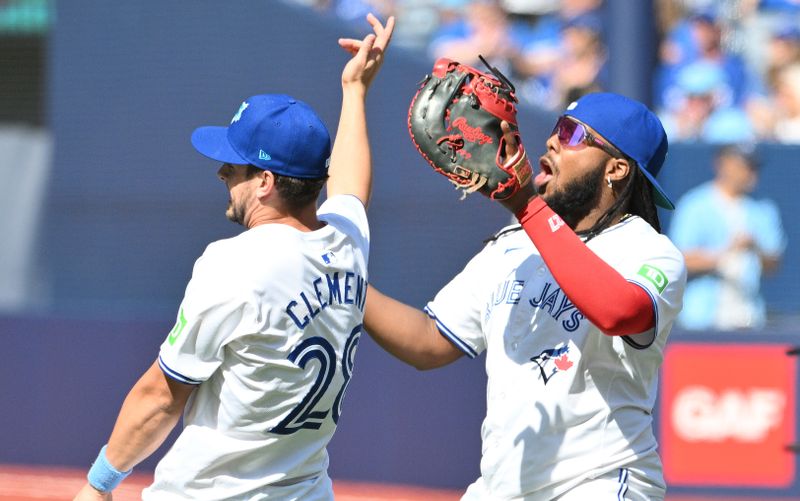 Jun 16, 2024; Toronto, Ontario, CAN;  Toronto Blue Jays first baseman Vladimir Guerrero Jr. (27) and third baseman Ernie Clement (28) celebrate after a win over the Cleveland Guardians at Rogers Centre. Mandatory Credit: Dan Hamilton-USA TODAY Sports