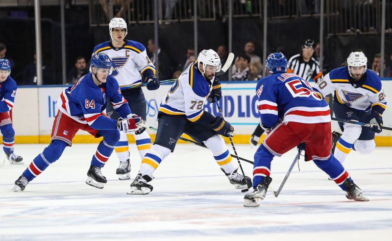 Nov 25, 2024; New York, New York, USA; St. Louis Blues defenseman Justin Faulk (72) plays the puck between New York Rangers center Adam Edstrom (84) and defenseman Ryan Lindgren (55) during the third period at Madison Square Garden. Mandatory Credit: Danny Wild-Imagn Images