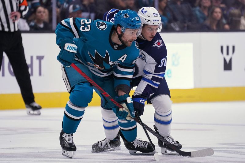 Nov 7, 2025; San Jose, California, USA; San Jose Sharks center Barclay Goodrow (23) vies for position against Winnipeg Jets right winger Nikita Chibrikov (90) before a faceoff in the first period at SAP Center at San Jose. Mandatory Credit: David Gonzales-Imagn Images