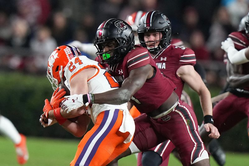 Nov 25, 2023; Columbia, South Carolina, USA; Clemson Tigers wide receiver Hamp Greene (24) is tackled by South Carolina Gamecocks wide receiver Xavier Legette (17) in the second half at Williams-Brice Stadium. Mandatory Credit: David Yeazell-USA TODAY Sports