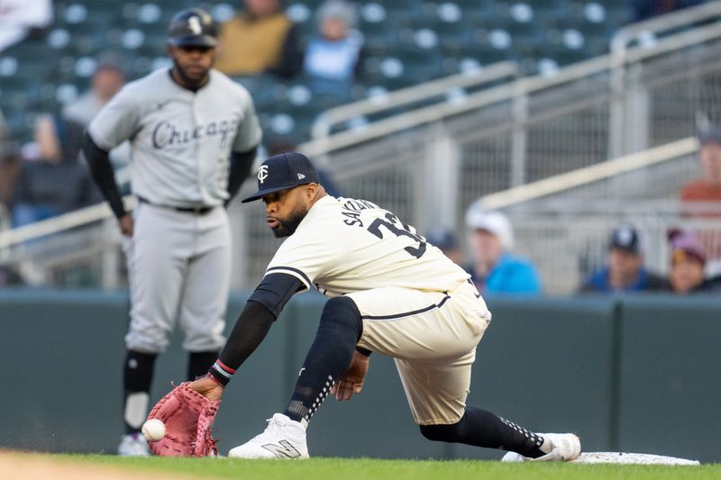 Apr 23, 2024; Minneapolis, Minnesota, USA; Minnesota Twins first baseman Carlos Santana (30) catches a throw from shortstop Willi Castro (not pictured) to retire Chicago White Sox catcher Martin Maldonado (not pictured) in the third inning at Target Field. Mandatory Credit: Matt Blewett-USA TODAY Sports