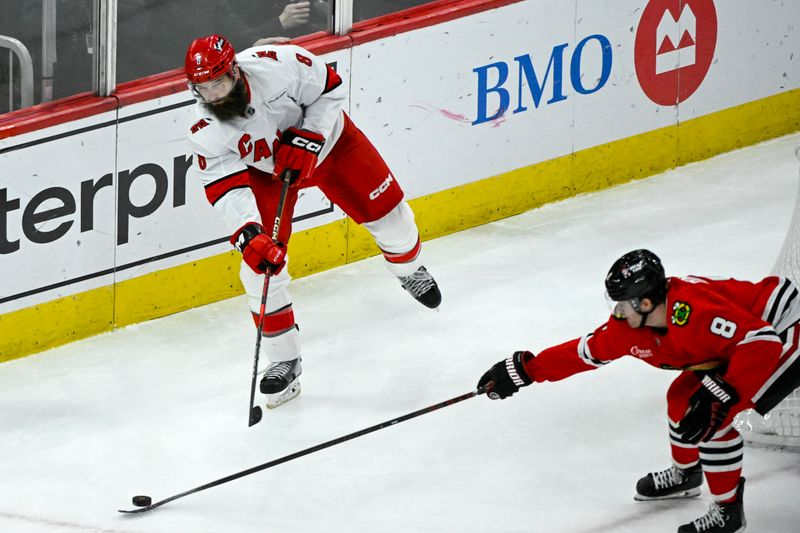 Jan 20, 2025; Chicago, Illinois, USA;  Carolina Hurricanes defenseman Brent Burns (8) moves the puck past Chicago Blackhawks center Ryan Donato (8) during the third period at the United Center. Mandatory Credit: Matt Marton-Imagn Images


