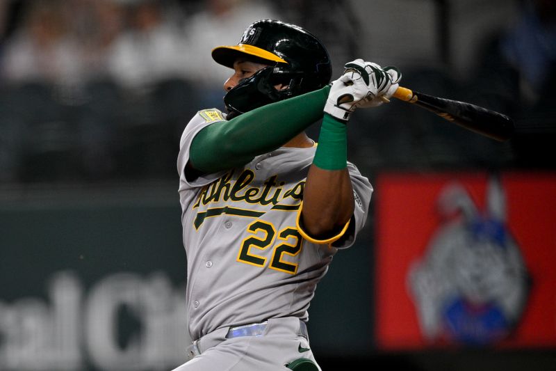May 1, 2025; Arlington, Texas, USA; Athletics third baseman Miguel Andujar (22) hits a single and drives in a run against the Texas Rangers during the first inning at Globe Life Field. Mandatory Credit: Jerome Miron-Imagn Images