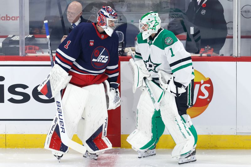 Nov 9, 2024; Winnipeg, Manitoba, CAN; Winnipeg Jets goaltender Eric Comrie (1) and Dallas Stars goaltender Casey DeSmith (1) talk before a game at Canada Life Centre. Mandatory Credit: James Carey Lauder-Imagn Images