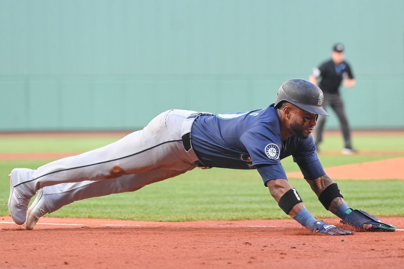 Jul 30, 2024; Boston, Massachusetts, USA; Seattle Mariners center fielder Victor Robles (10) slides into home plate against the Boston Red Sox during the first inning at Fenway Park. Mandatory Credit: Eric Canha-USA TODAY Sports