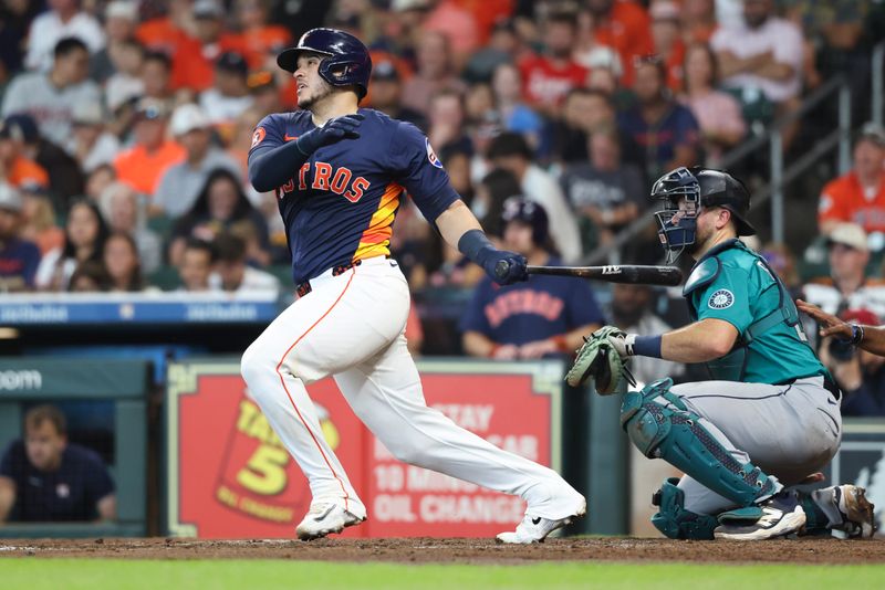 May 25, 2025; Houston, Texas, USA; Houston Astros catcher Yainer Diaz (21) hits a single during the second inning against the Seattle Mariners at Daikin Park. Mandatory Credit: Troy Taormina-Imagn Images