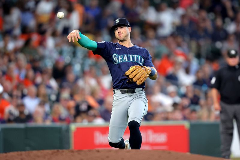 Sep 25, 2024; Houston, Texas, USA; Seattle Mariners third baseman Dylan Moore (25) throws a fielded ball to first base for an out against the Houston Astros during the third inning at Minute Maid Park. Mandatory Credit: Erik Williams-Imagn Images