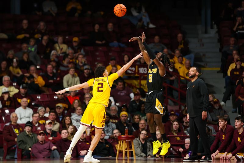 Nov 21, 2023; Minneapolis, Minnesota, USA; Arkansas-Pine Bluff Golden Lions guard Rashad Williams (5) shoots against Minnesota Golden Gophers guard Mike Mitchell Jr. (2) during the first half at Williams Arena. Mandatory Credit: Matt Krohn-USA TODAY Sports