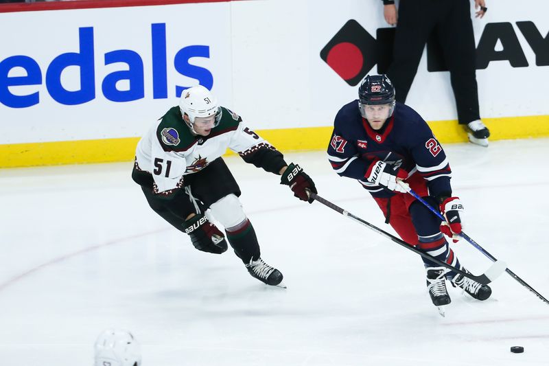 Nov 18, 2023; Winnipeg, Manitoba, CAN;  Winnipeg Jets forward Nikolaj Ehlers (27) skates away from Arizona Coyotes defenseman Troy Stecher (51) during the third period at Canada Life Centre. Mandatory Credit: Terrence Lee-USA TODAY Sports