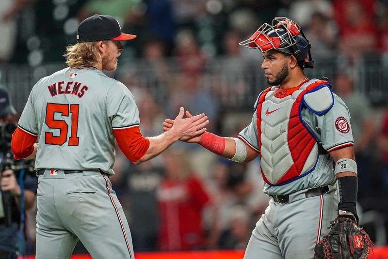 May 29, 2024; Cumberland, Georgia, USA; Washington Nationals relief pitcher Jordan Weems (51) and catcher Keibert Ruiz (20) react after defeating the Atlanta Braves at Truist Park. Mandatory Credit: Dale Zanine-USA TODAY Sports