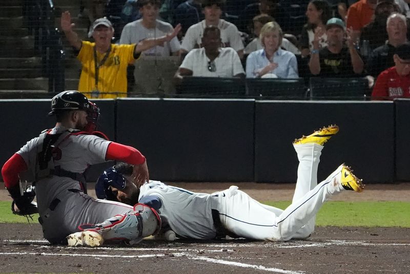 Sep 21, 2025; Tampa, Florida, USA; Tampa Bay Rays third base Junior Caminero (13) dives into home base safely as Boston Red Sox catcher Connor Wong (12) tries to make the tag during the first inning at George M. Steinbrenner Field. Mandatory Credit: Dave Nelson-Imagn Images