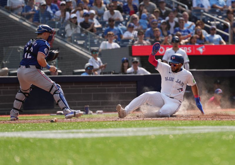 Jul 27, 2024; Toronto, Ontario, CAN; Toronto Blue Jays left fielder Steward Berroa (37) slides into home plate scoring a run against the Texas Rangers during the sixth inning at Rogers Centre. Mandatory Credit: Nick Turchiaro-USA TODAY Sports