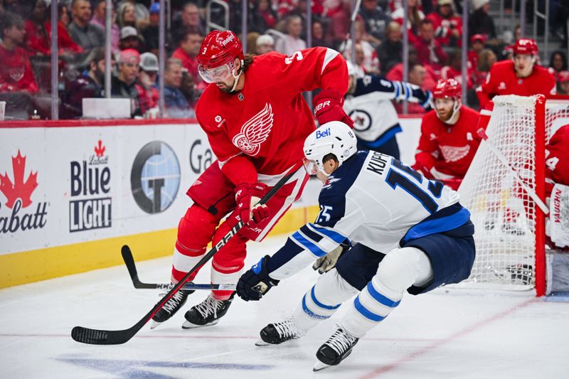 Oct 30, 2024; Detroit, Michigan, USA; Detroit Red Wings defenseman Justin Holl (3) and Winnipeg Jets center Rasmus Kupari (15) battle for the puck during the game at Little Caesars Arena. Mandatory Credit: Tim Fuller-Imagn Images