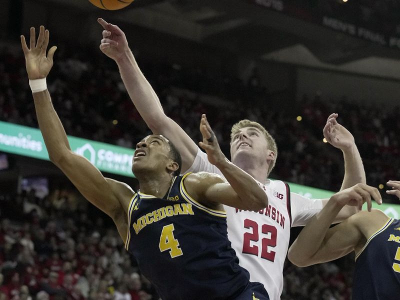 Dec 3, 2024; Madison, Wisconsin, USA; Michigan guard Nimari Burnett (4) tries to score on Wisconsin forward Steven Crowl (22) during the first half of their game Tuesday, December 3, 2024 at the Kohl Center in Madison, Wisconsin.  Mandatory Credit: Mark Hoffman/USA TODAY Network via Imagn Images 