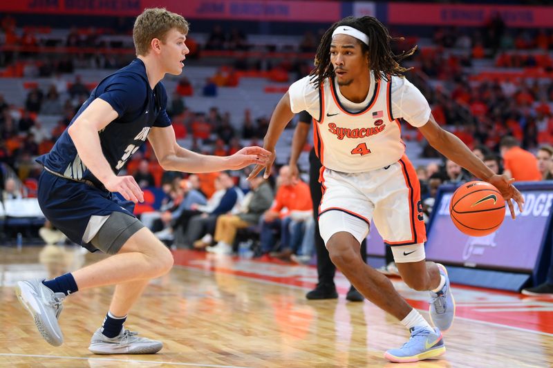 Nov 6, 2023; Syracuse, New York, USA; Syracuse Orange forward Chris Bell (4) drives to the basket against the defense of New Hampshire Wildcats forward Trey Woodyard (33) during the second half at the JMA Wireless Dome. Mandatory Credit: Rich Barnes-USA TODAY Sports