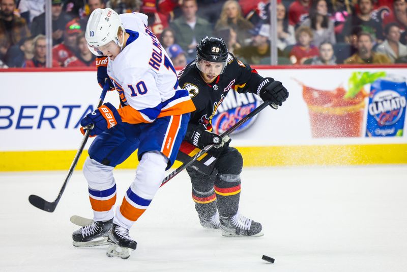 Nov 18, 2023; Calgary, Alberta, CAN; Calgary Flames center Elias Lindholm (28) controls the puck against New York Islanders right wing Simon Holmstrom (10) during the first period at Scotiabank Saddledome. Mandatory Credit: Sergei Belski-USA TODAY Sports