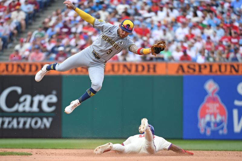 Jun 1, 2025; Philadelphia, Pennsylvania, USA; Milwaukee Brewers shortstop Joey Ortiz (3) leaps to catch throw as Philadelphia Phillies outfielder Johan Rojas (23) steals second base during the fourth inning at Citizens Bank Park. Mandatory Credit: Eric Hartline-Imagn Images