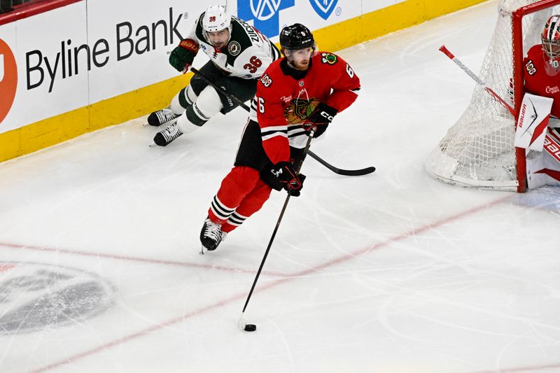 Mar 17, 2026; Chicago, Illinois, USA;  Chicago Blackhawks defenseman Sam Rinzel (6) moves the puck away from Minnesota Wild right wing Mats Zuccarello (36) during the second period at United Center. Mandatory Credit: Matt Marton-Imagn Images