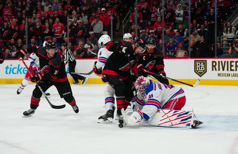 Mar 12, 2024; Raleigh, North Carolina, USA; New York Rangers goaltender Igor Shesterkin (31) gets the puck away from Carolina Hurricanes center Sebastian Aho (20)  right wing Andrei Svechnikov (37) and center Jordan Staal (11) during the third period at PNC Arena. Mandatory Credit: James Guillory-USA TODAY Sports