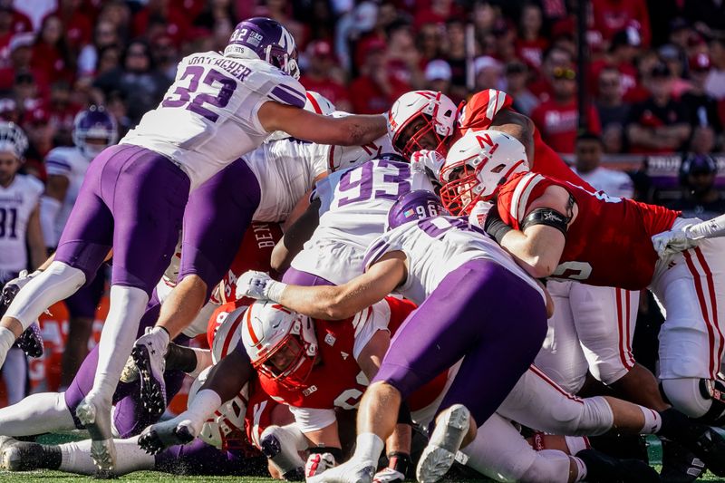 Oct 21, 2023; Lincoln, Nebraska, USA; Nebraska Cornhuskers linemen push quarterback Heinrich Haarberg (10) forward for a first down against Northwestern Wildcats defenders during the second quarter at Memorial Stadium. Mandatory Credit: Dylan Widger-USA TODAY Sports