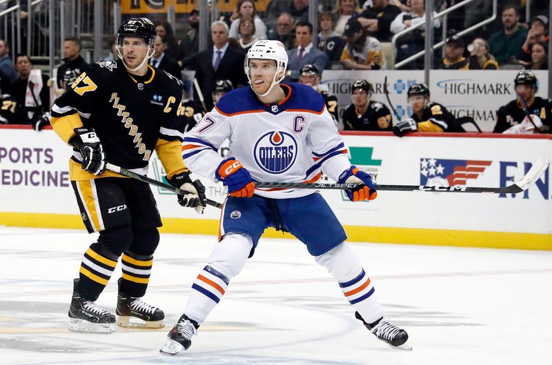 Feb 23, 2023; Pittsburgh, Pennsylvania, USA;  Pittsburgh Penguins center Sidney Crosby (87) and Edmonton Oilers center Connor McDavid (97) skate up ice during the second period at PPG Paints Arena. Mandatory Credit: Charles LeClaire-USA TODAY Sports