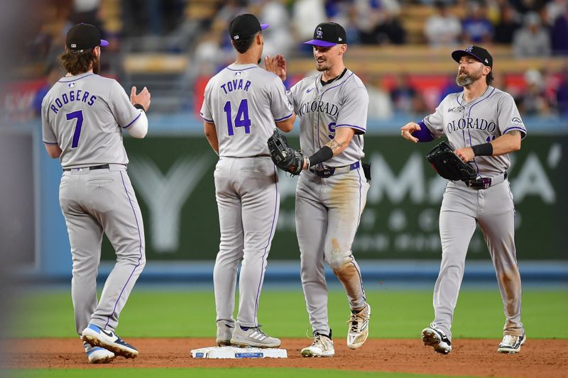 May 31, 2024; Los Angeles, California, USA; Colorado Rockies second baseman Brendan Rodgers (7) shortstop Ezequiel Tovar (14) center fielder Brenton Doyle (9) and left fielder Jake Cave (11) celebrate the victory against the Los Angeles Dodgers  at Dodger Stadium. Mandatory Credit: Gary A. Vasquez-USA TODAY Sports