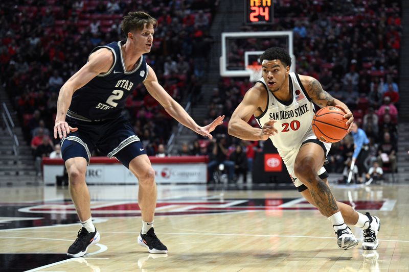 Jan 25, 2023; San Diego, California, USA; San Diego State Aztecs guard Matt Bradley (20) dribbles the ball while defended by Utah State Aggies guard Sean Bairstow (2) during the first half at Viejas Arena. Mandatory Credit: Orlando Ramirez-USA TODAY Sports