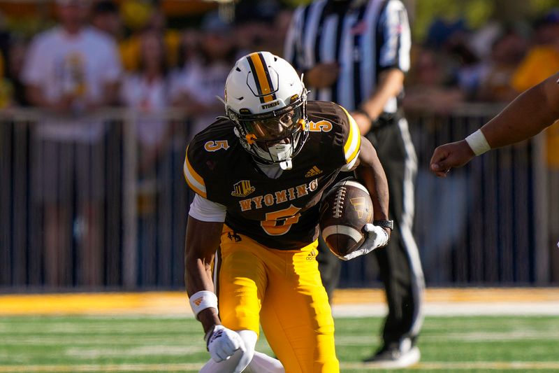 Sep 30, 2023; Laramie, Wyoming, USA; Wyoming Cowboys wide receiver Ayir Asante (5) runs for a touchdown against the New Mexico Lobos during the third quarter at Jonah Field at War Memorial Stadium. Mandatory Credit: Troy Babbitt-USA TODAY Sports

