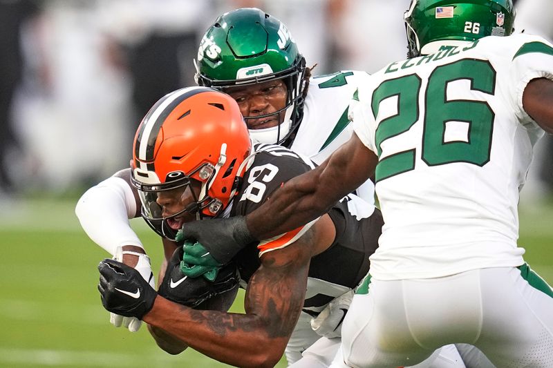 Cleveland Browns wide receiver Cedric Tillman (89) is tackled by New York Jets linebacker Jamien Sherwood (44), and cornerback Brandin Echols (26) during the first half of the Hall of Fame NFL football preseason game Thursday, Aug. 3, 2023, in Canton, Ohio. (AP Photo/Sue Ogrocki)