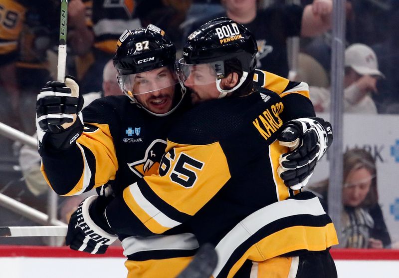 Apr 15, 2024; Pittsburgh, Pennsylvania, USA;  Pittsburgh Penguins center Sidney Crosby (87) and defenseman Erik Karlsson (65) celebrate a goal by Karlsson against the Nashville Predators during the first period at PPG Paints Arena. The Penguins won 4-2. Mandatory Credit: Charles LeClaire-USA TODAY Sports